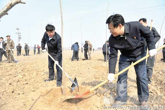 圖為康志民、王春利同黨員志愿者一起參加義務植樹活動。 記者 永翔 攝